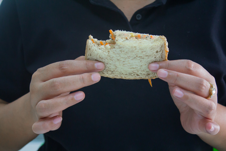 People wearing black t-shirts are eating delicious tuna sandwiches.の写真素材