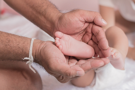Soft foot of baby in Father's hand.の写真素材