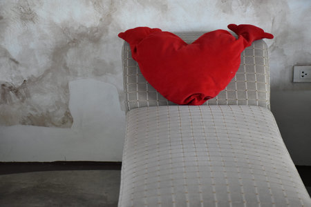 Red heart pillow on sofa in living room, Valentine's day concept