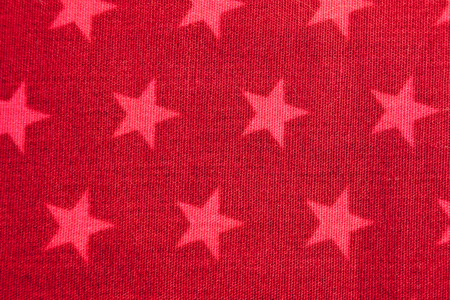 Fabric pattern showing pink stars on a red backgroundの写真素材