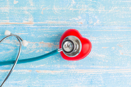 Closeup red heart and stethoscope on vintage wooden blue backgroundの写真素材