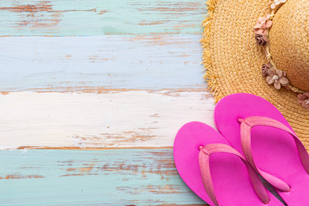 Pink sandals and brown straw hat on beach color wooden backgroundの写真素材