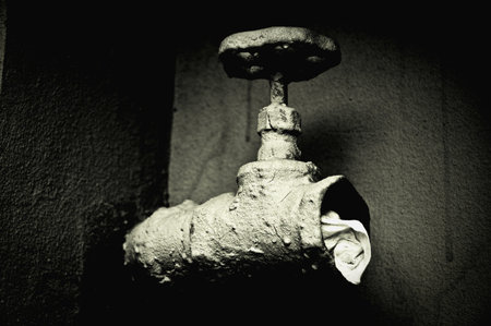 Closeup image of a sewer valve. Black and white photo, high contrast