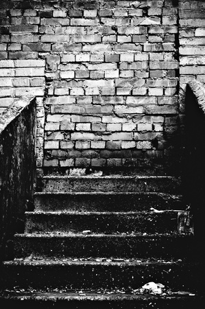 The strange staircase leading into brick wall. Black and white photo in low keyの写真素材