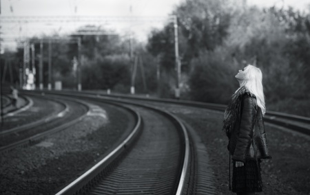 Portrait of beautiful young girl waiting for the train at the railroad tracks  Black and whiteの写真素材