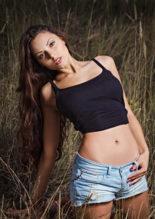 A sexy young girl in a field at evening time の写真素材