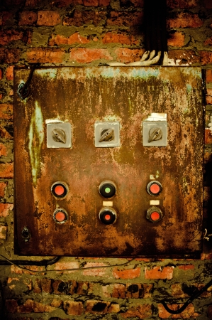 An old rusty control panel on the brick wallの写真素材