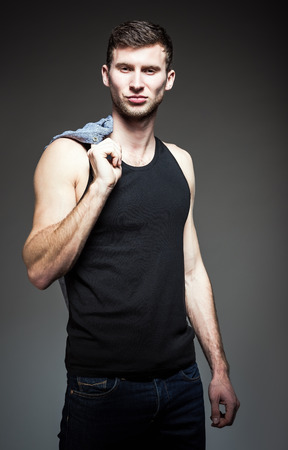 Studio fashion shot  a handsome young man wearing jeans and shirt の写真素材