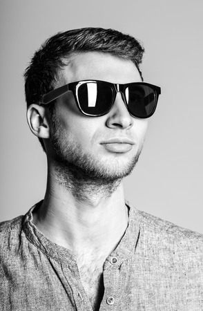 Portrait of a handsome young man wearing sunglasses  Black and whiteの写真素材