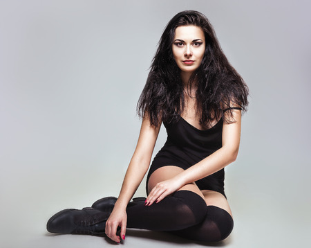 Portrait of pretty young girl in black dress and stockings  Studio shotの写真素材
