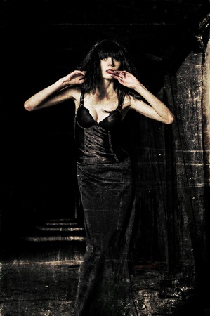 A beautiful goth girl among the dark  Grunge texture effectの写真素材