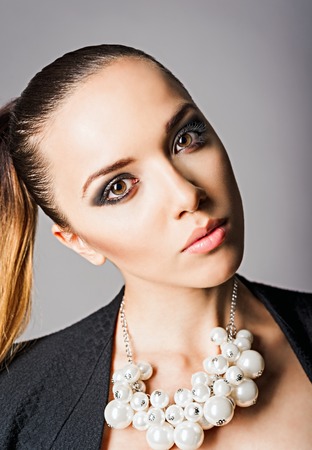 Closeup portrait of a beautiful young woman wearing pearl necklaceの写真素材