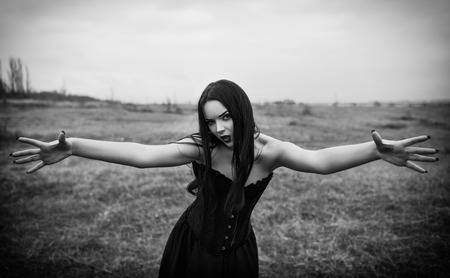 Wicked dangerous goth girl in the autumnal field. Black and whiteの写真素材