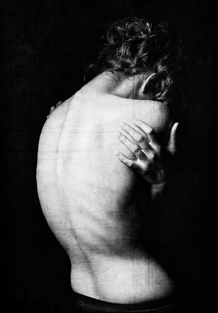 Spooky portrait of a young woman among the dark. Grunge texture effect. Black and white, rear viewの写真素材