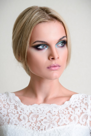 Studio fashion shot: a beautiful young woman in white dress の写真素材
