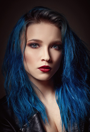 Closeup studio portrait of a beautiful young woman with blue hair の写真素材