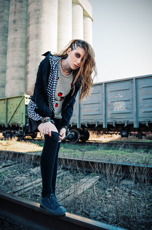 Outdoor portrait of the beautiful grunge (rock) girl at the railsの写真素材