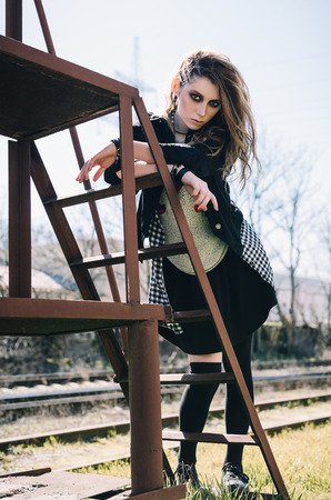 Outdoor portrait of the pretty grunge (rock) girl at the railroadの写真素材