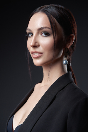 Studio portrait of the beautiful young woman. Close-up of pretty girl against dark gray backgroundの写真素材