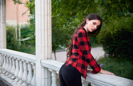 City fashion: portrait of beautiful young girl wearing checkered shirt and jeans 
