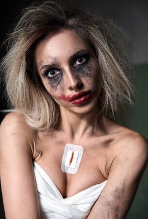 Strange crazy girl. Insane sad young woman (freak) with messy make-up. Portrait of the madman (mental sick)の写真素材