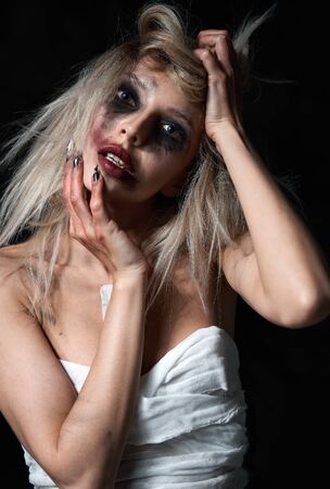 Weird mad girl. Morbid sad young woman (freak) with messy make-up. Portrait of the madman (mental sick)の写真素材