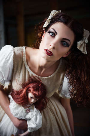 Portrait of a strange girl with dollの写真素材