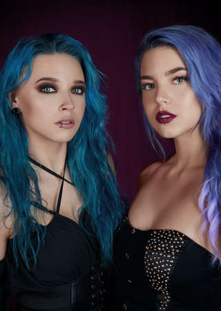 Two blue-haired informal (rock) girls. Close-up portrait of 2 lovely women. Dark beautyの写真素材