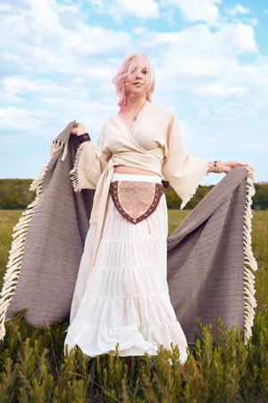 Outdoor fashion: portrait of the beautiful young boho (hippie) girl in field. Lovely hippy woman in meadowの写真素材