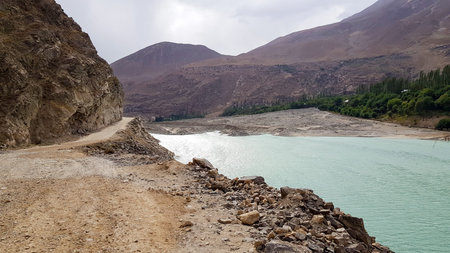 Gravel balcony road along to river middle of mountains.