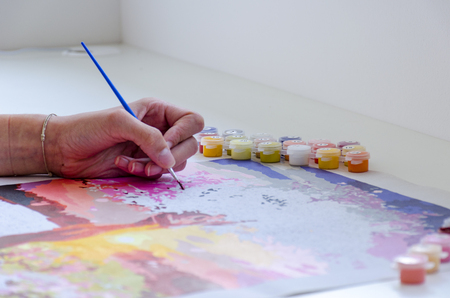 Hand of young woman is painting by brush a picture on the table.の写真素材