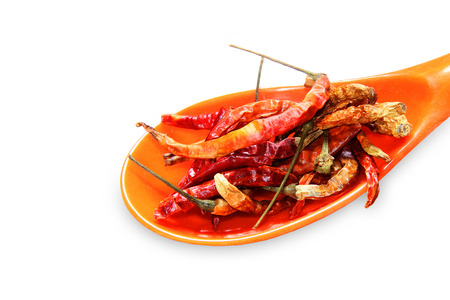 dried Chilli in a orange spoon isolated on a white backgroundsの写真素材