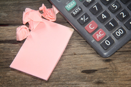 Calculator and paper on a wooden background の写真素材