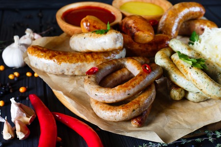 Sausage assortment on black background decorated with garlic, peの写真素材