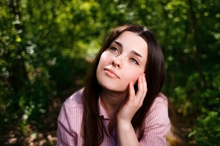 Portrait of dreamy young woman with hand over faceの写真素材