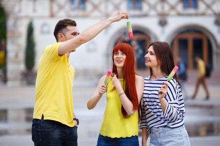 Group of three friends walking in the city eating ice cream, jokの写真素材