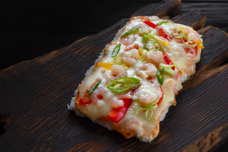 Delicious japanese rice pizza with shrimps served on rustic woodの写真素材