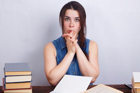 Portrait of young stunned surprised shocked student woman sittinの写真素材