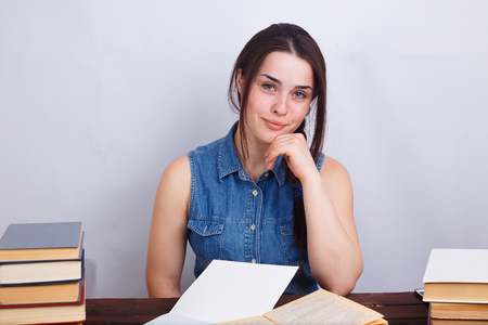 Young smiling student woman sitting at the deskの写真素材