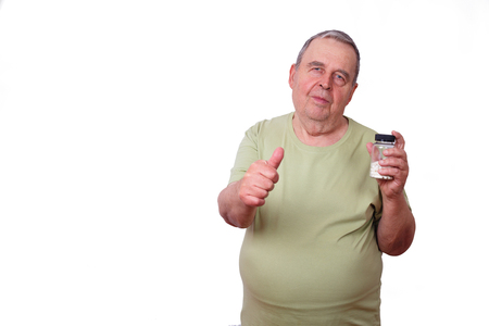 Portrait of old overweight man with pills in hand and thumb up gの写真素材