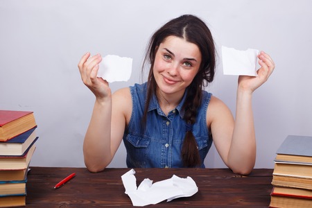 Young smiling woman tearing a sheet of paper, firing, dismissalの写真素材
