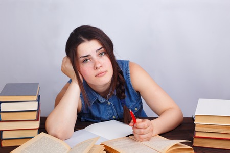 Young lazy bored student woman sitting at the table with text boの写真素材