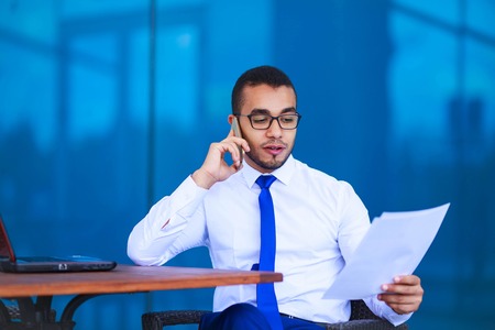 Business man working with laptop and documents, talking on the phone. Consultant, paperwork conceptの写真素材