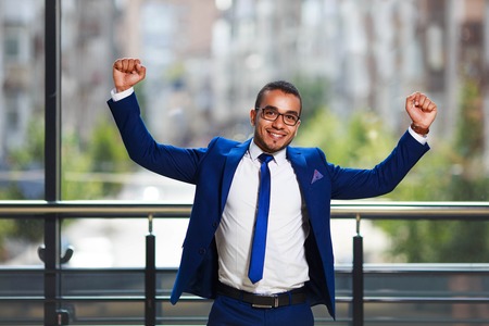 Young businessman celebrating success, expressing positivity whiの写真素材