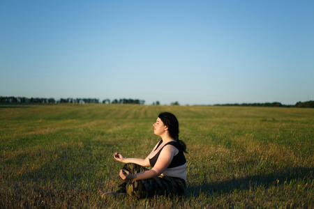Overweight fat woman meditating outdoors. Yoga, weight losing, hの写真素材