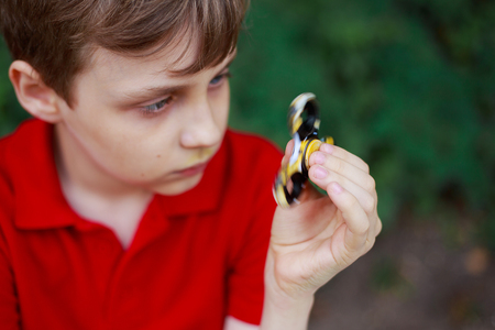 Boy playing with fidget spinner, close up. Trendy gadgets, enterの写真素材