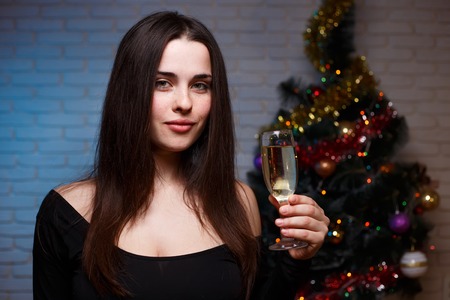 Young beautiful woman in evening dress with a glass of champagneの写真素材