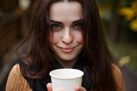 Close up portrait of young pretty smiling woman wearing knittedの写真素材