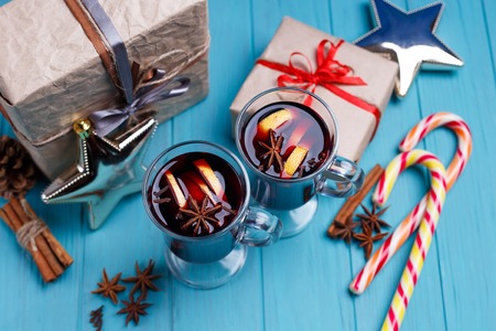 Mulled wine, gift boxes, candies and decorations on bright backgの写真素材
