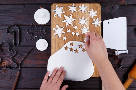 Woman cutting decorations in form of stars and snowflakes of conの写真素材
